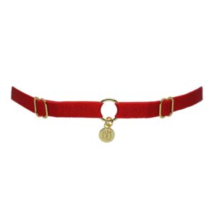 Aquí puede ver el BRIGADE MONDAINE GIFT WRAP RED. Este collar está hecho de una banda roja. Hay 2 detalles para ajustar las bandas a la derecha y a la izquierda. En el centro, la banda está separada por un anillo chapado en oro con un colgante que dice "BM".
