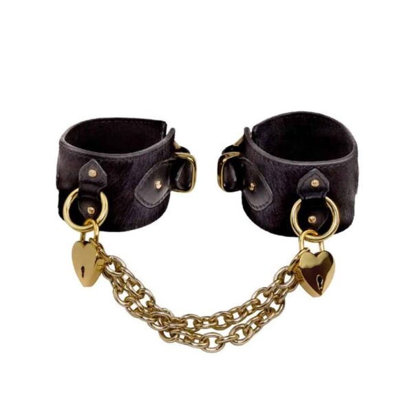 Lederhandschellen in Schwarz mit weichen Borsten, goldenen Herzschlössern und goldenen Ketten zum Verbinden der beiden Armbänder.