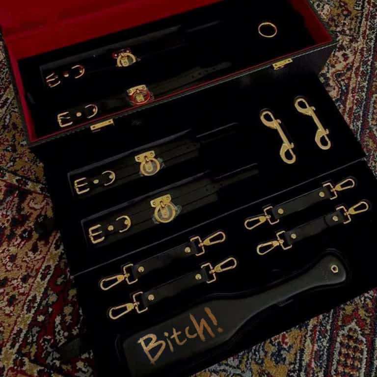 Tronco d' accesorios de bondage y BDSM en cuero negro y oro de 24K totalmente hechos a mano y fondo de terciopelo UPKO en Brigade Mondaine