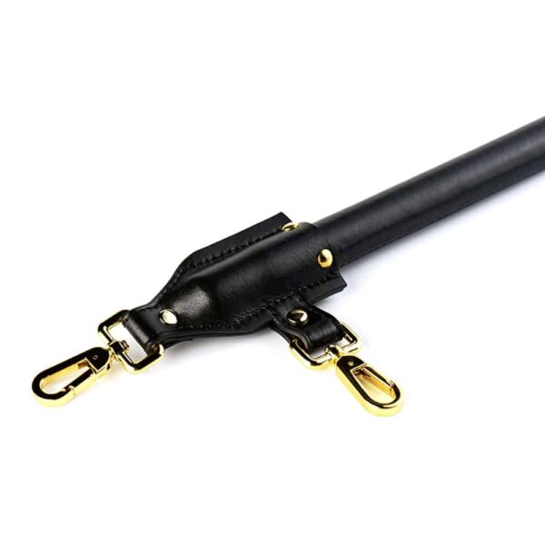 Black leather spreader bar with gold finish, attachable to UPKO wrists and ankles at Brigade Mondaine