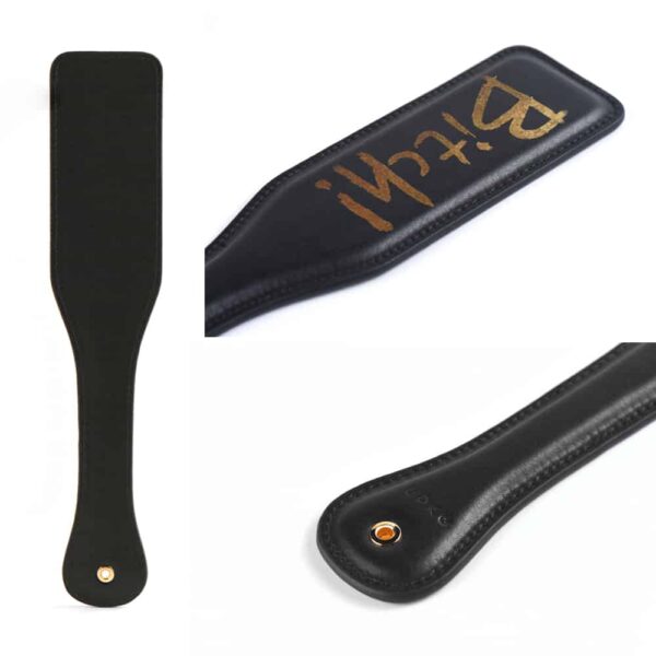 Spanking-Paddle aus schwarzem Leder mit Goldfinish und goldenem UPKO-Schriftzug bei Brigade Mondaine