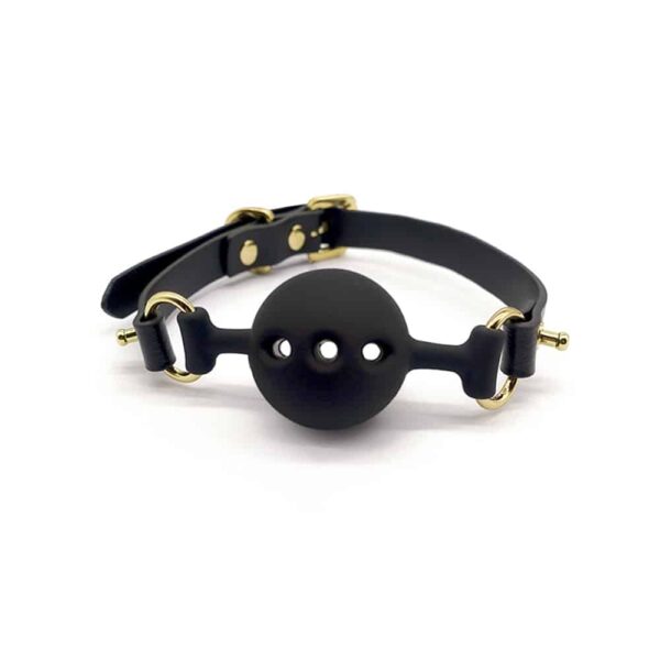 Black leather and silicone baillon in the shape of a ball with holes for breathing, gold finish UPKO at Brigade Mondaine