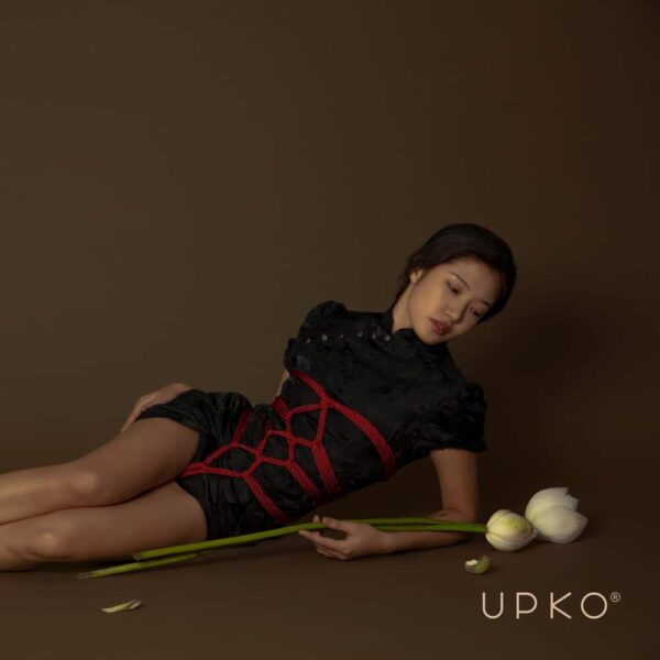 Cuerda Shibari roja de la marca UPKO. El maniquí lleva una cuerda entrelazada de 10 m de longitud y 6 mm de diámetro.
