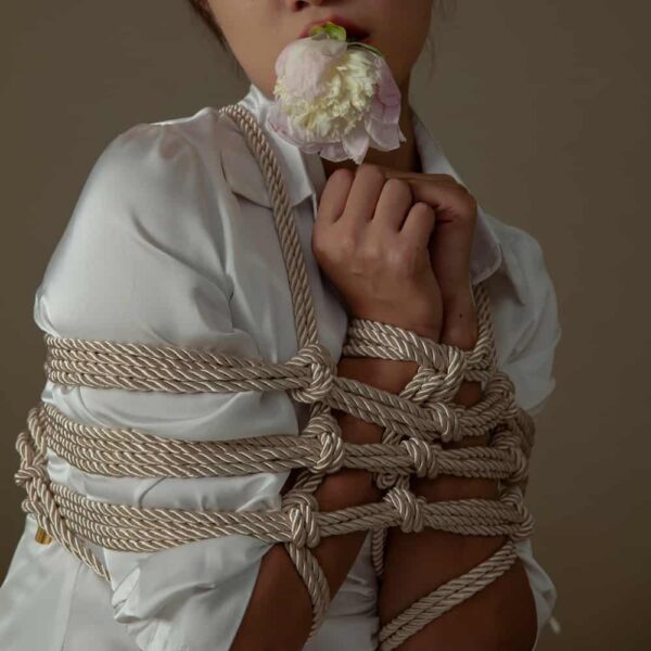 Corde Shibari de couleur crème de la marque UPKO. Le mannequin porte un entrelacement de cordes d'une longueur de 10 m et d'un diamètre de cordon de 6mm.