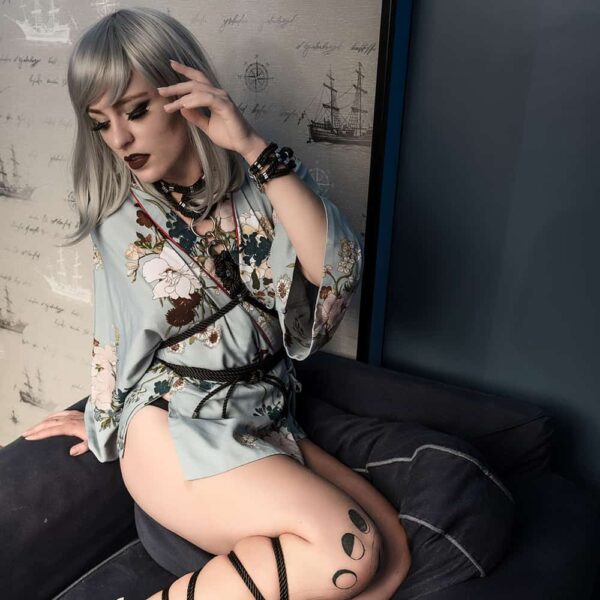 Harness with black rope collar, tightened at the waist and silver details on a blue floral kimono