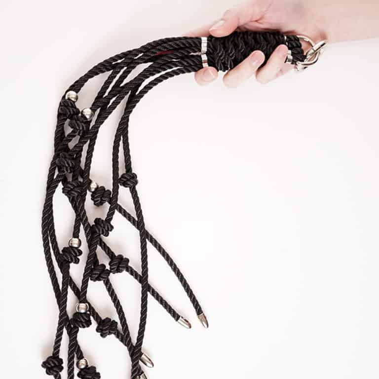 Black rope whip with small knots and silver details for more sensations