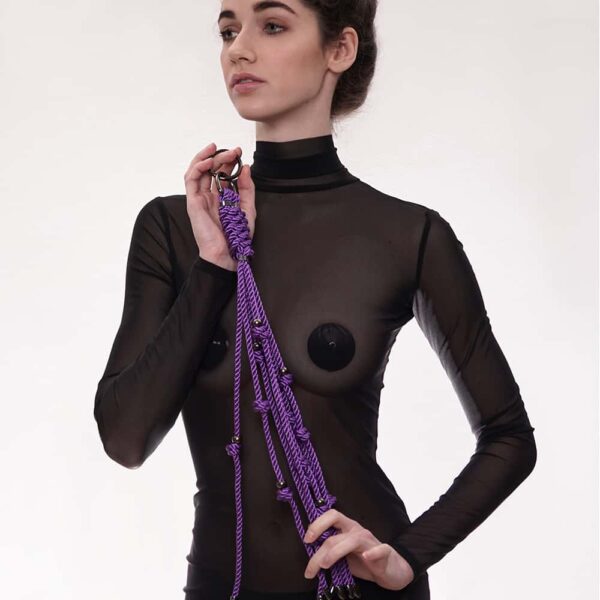 Figura de Un látigo grande, de color morado, con cordones de algodón encerado y cuentas plateadas de acero inoxidable. El producto tiene ocho hebras y un mosquetón que se puede enganchar a un collar o a un bolso.