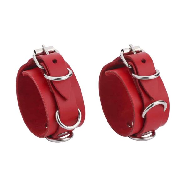 Thin red leather handcuffs with silver detailing and fasteners