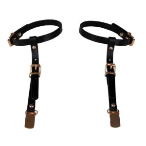 Black leather arm harness from Elif Domanic. This product is made of an arm loop and a hanging strap decorated with golden ties, clips and nails. A buckle allows to attach and maintain the product around the arm.
