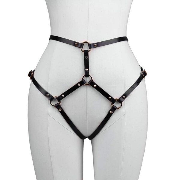 Harness briefs Doris in black leather by Elif Domanic. These panties are made of a triangle for the lower abdomen which is connected to the waist by a strap. At the back two straps in the shape of panties maintain the buttocks. The whole is connected by golden brass rings and some nails on both sides of the product. The harness is attached to the lower back with a thin gold buckle.