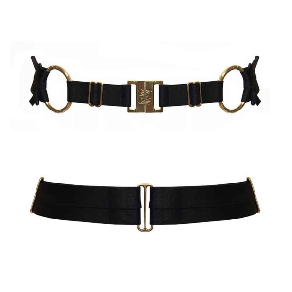 Ceinture noire de la marque Bordelle. Le produit est confectionné à partir d’élastiques en satin et de fermoirs en or 24 carats. La fermeture sur le devant est griffé du nom de la marque. Deux anneaux couleur doré ornementent le produit et le structure en tenant dans le dos un élastique plus épais muni de deux petits noeuds aux extrémités. Sur le devant deux élastiques joignent les deux fermoirs centraux.