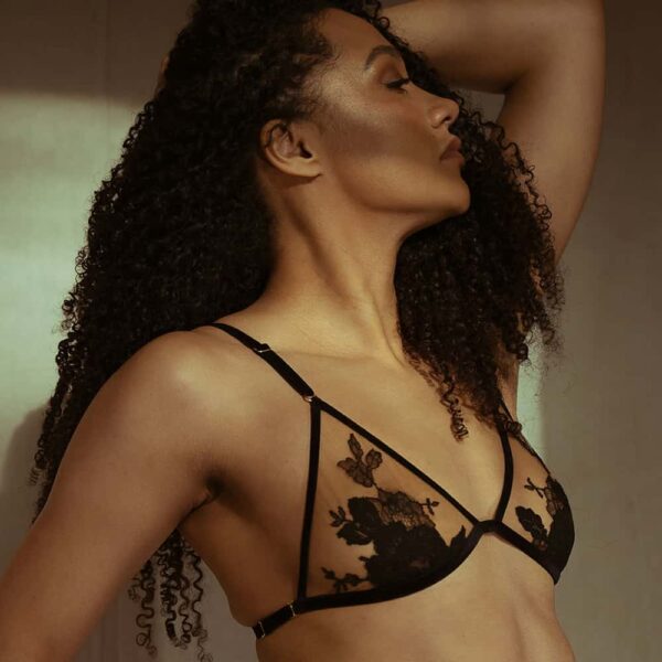 Nude Rich Tawny Collection Symbioticy triangle bra by HERVÉ by Céline Marie. The shape is ensured by black velvet elastics and a transparent fabric decorated with black lace. The rings of the bra are golden.