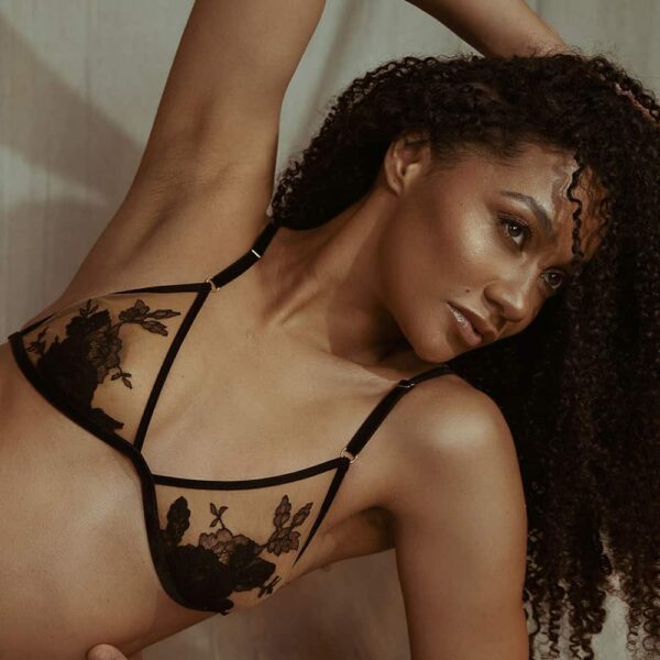 Nude Rich Tawny Collection Symbioticy triangle bra by HERVÉ by Céline Marie. The shape is ensured by black velvet elastics and a transparent fabric decorated with black lace. The rings of the bra are golden.
