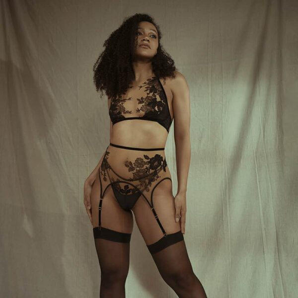 Suspender belt Yvea Nude Rich Tawny Collection Symbioticy by HERVE BY CELINE MARIE. The suspender belts are shaped with black velvet elastics and a transparent fabric decorated with black lace. The clasps of the garter belts are golden.