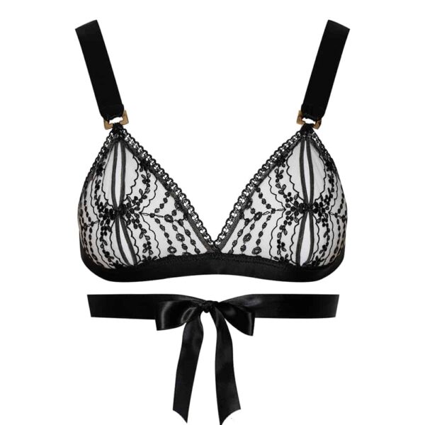 Lace bra with black flowery patterns from the brand Cadolle. The straps are made of thick black satin ribbons and the band supporting the breasts is made of the same black satin ribbon material. The light and delicate design of the cups is reinforced by the thicker but noble straps. The band supporting the underside of the bust goes around the back and comes back to tie in a knot at the front.