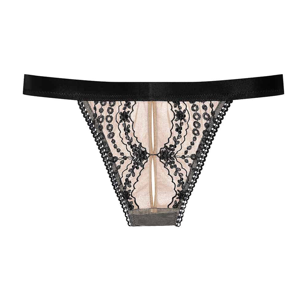 Cadolle panties from the Joli collection, made of black embroidery from a floral universe on a skin colored tulle. A black elastic is placed around the hips. The back of the panties is opaque and black.