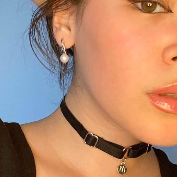 BM necklace included in the Brigade Mondaine gift pack. The product is a simple choker with a black elastic necklace and a gold pendant embossed with the Brigade Mondaine logo. This jewelry is attached to the necklace by a ring. The whole product is adjustable.