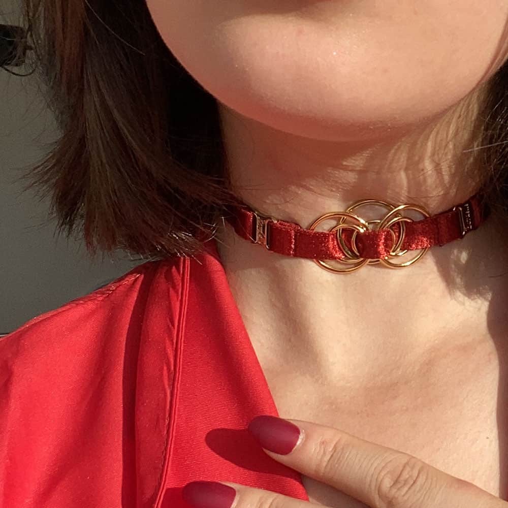 Bordelle und Brigade Mondaine Halskette, die in der roten Geschenkpackung erhältlich ist. Die Halskette ist dünn und hat goldene Details.