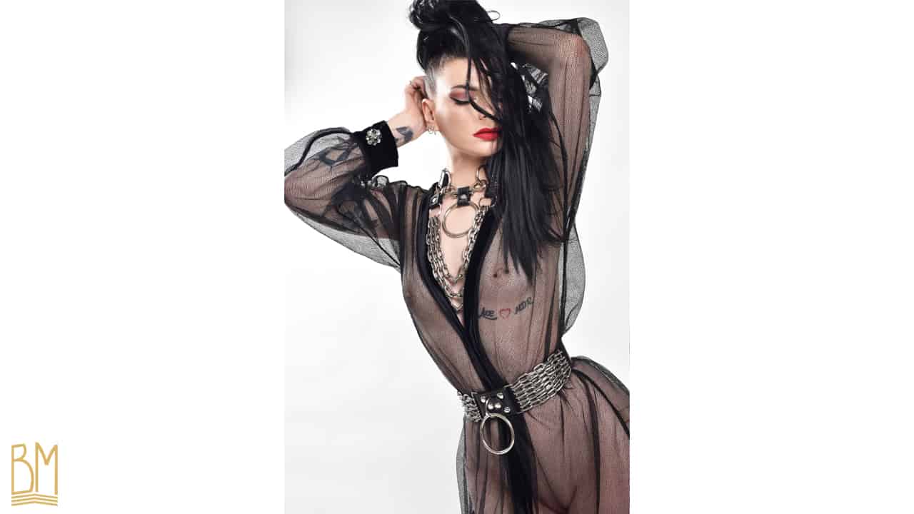 Sesión fotográfica de Lada Vesna photography en colaboración con Brigade Mondaine con la modelo Julie Von Trash que lleva la marca Upko. El Kimono Bijoux et Résille negro está hecho de malla y tiene joyas como gemelos. Viene con un cinturón de tela en la cintura.