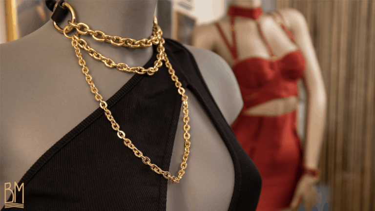 Podemos ver un maniquí que lleva un chocker bondage de Elif Domanic en color dorado. Tiene cadenas de oro y una correa de cuero negro en el cuello.