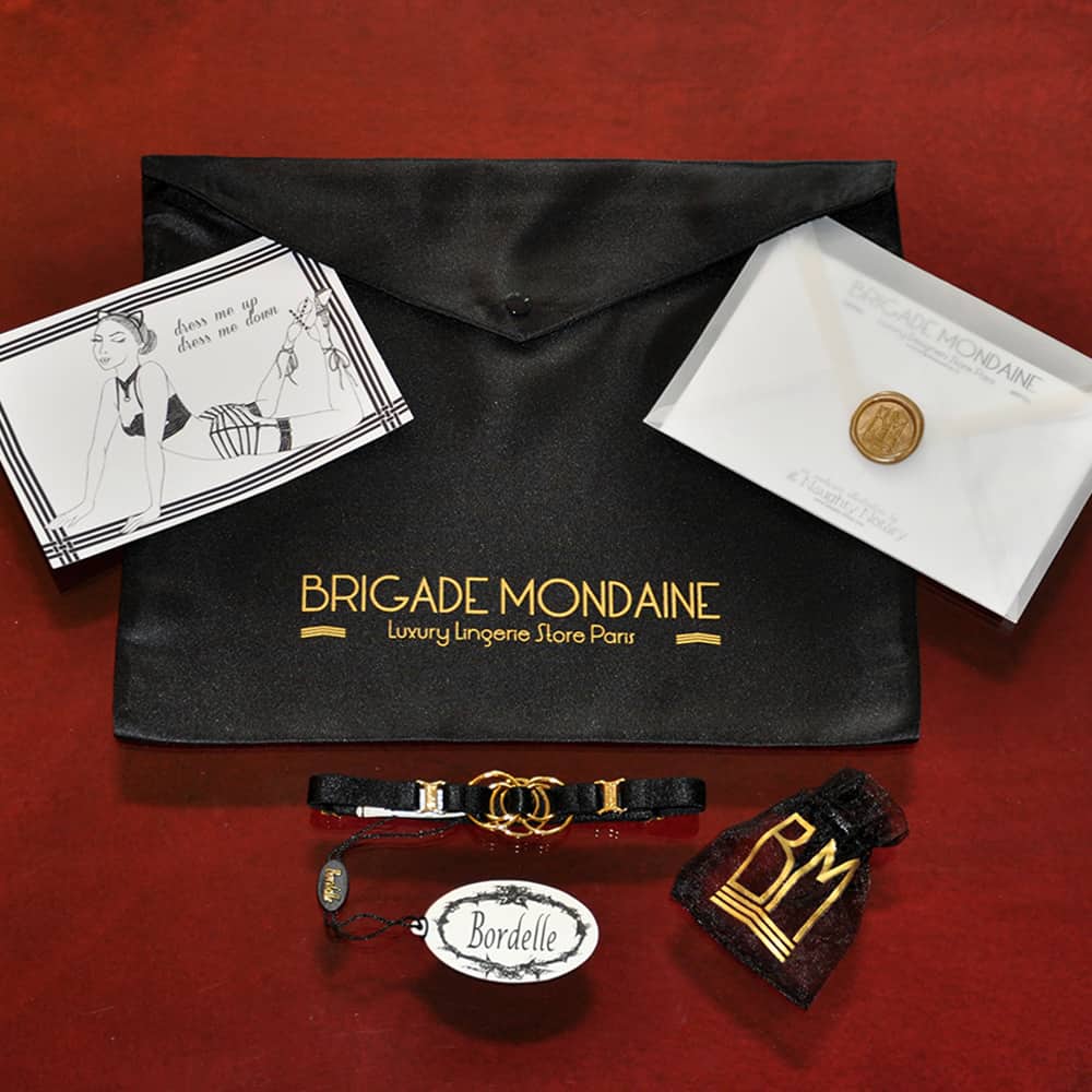Luxury gift wrap, Bordelle und Brigade Mondaine Halskette Bordelle erhältlich in der schwarzen Geschenkpackung.Die Halskette ist dünn und hat goldene Details.