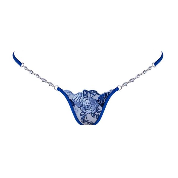 Le mannequin porte le Blue Lagoon de la marque Lucky Cheeks. Derrière le string est composé d’une petite partie de tulle bleu. Dessus une feuille bleue est cousue pour rappeler les roses du devant. Au niveau des hanches, les bandes du string sont bleues.