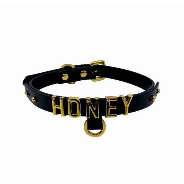 Necklace / choker in soft black Italian leather with 24 karat gold plated letters and a small stone encrusted on each letter writing the word HONEY from the UPKO X Brigade Mondaine collection available at Brigade Mondaine