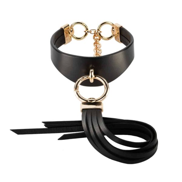 Ava Black leather necklace from Asche&Gold available at Brigade Mondaine. The necklace is thick, made of leather with gold finishes. In front there is a long black leather fringe hanging on a gold buckle.
