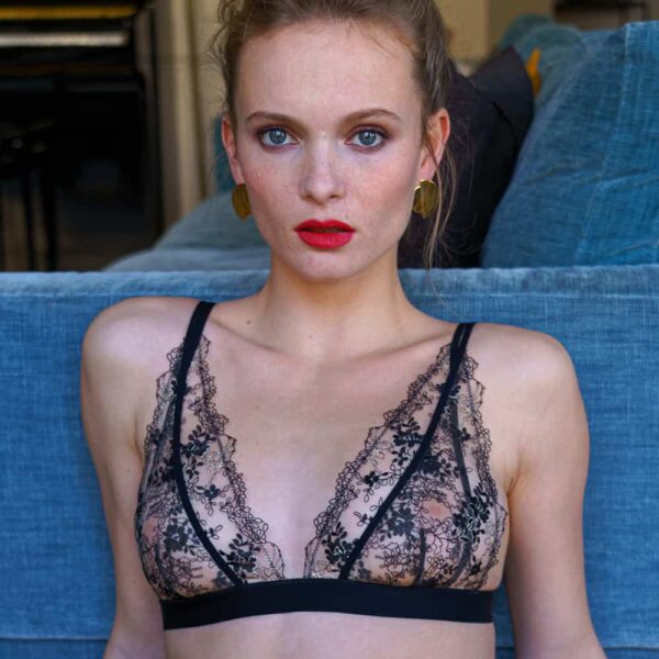 Soutien gorge en dentelle de couleur transparente et noir, une bande élastique satiné se tien en dessous des seins. Produit d'atelier amour chez brigade mondaine.