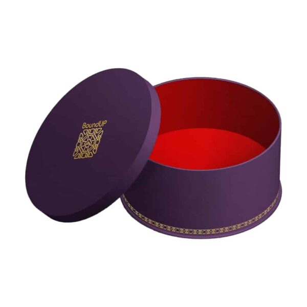 Корсет, когда ваше желание исполняется BoundUp. Это фиолетовая коробка с золотыми узорами на дне. Внутренняя часть коробки красного цвета, на крышке - логотип BoundUp.