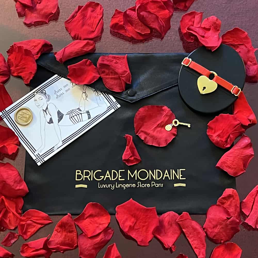 Le pack cadeau de la Saint Valentin 2022 contient en exclusivité un choker cadenas (rouge ou noir), accompagné d'un pochon en soie Brigade Mondaine pour emballer votre lingerie ou vos accessoires préférés, ainsi qu'une superbe carte à personnaliser. Parfait pour un cadeau homme ou un cadeau femme !