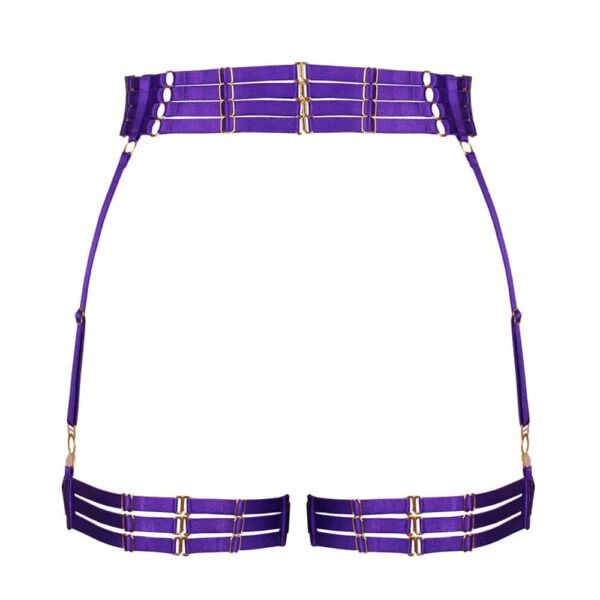 Strapsgürtel Electra Violett von der Marke Kaimin. Diese Strapsgürtel haben eine einfache Form und zeichnen sich durch ihre ausgefallene violette Farbe aus. Der Gürtel besteht aus einem breiten Gummiband auf der Vorderseite mit einem Mittelring und auf den Hüften entwickeln sich vier kleine Gummibänder, die nacheinander auf der Rückseite mit kleinen goldenen Haken eingehakt werden. Die Strumpfbänder bestehen aus doppelten, überkreuzten Gummibändern auf der Vorderseite und weiteren kleinen Gummibändern.