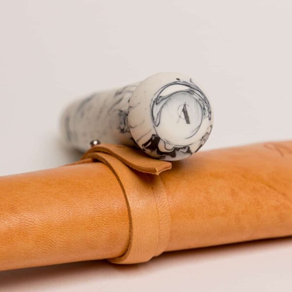 Orange leather packaging. 20 CM long plug, round shape, black and white marble effect.