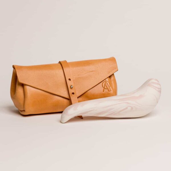 Orange leather pouch with the brand's logo on it. The thick spur on the top and thinner tip, it is porcelain colored pink and white from Adeles Brydges at brigade mondaine