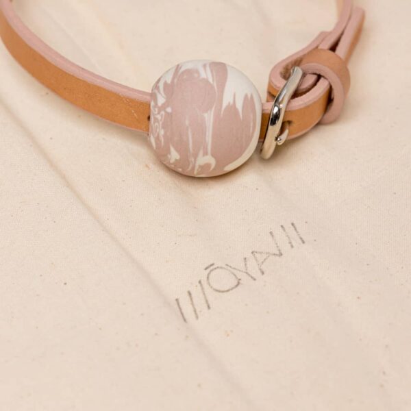 Collier OYA orangé mini balle au centre du collier fait en porcelaine rose et blanc de adules brydges chez brigade mondaine.