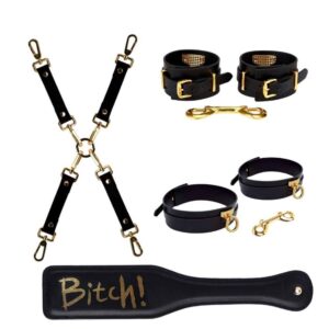 Set composed of a black leather hogtie with 24 carat finish, golden carabiners, golden handcuffs with 24 carat finish, black leather paddle, the word "Bitch" is written on it in golden color at brigade mondaine
