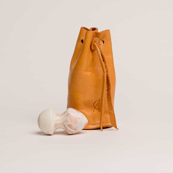 Pochette en cuir orangé avec le logo de la marque dessus .Plug petit à un embout en pique de couleur rose et blanche de adules brydges chez brigade mondaine.