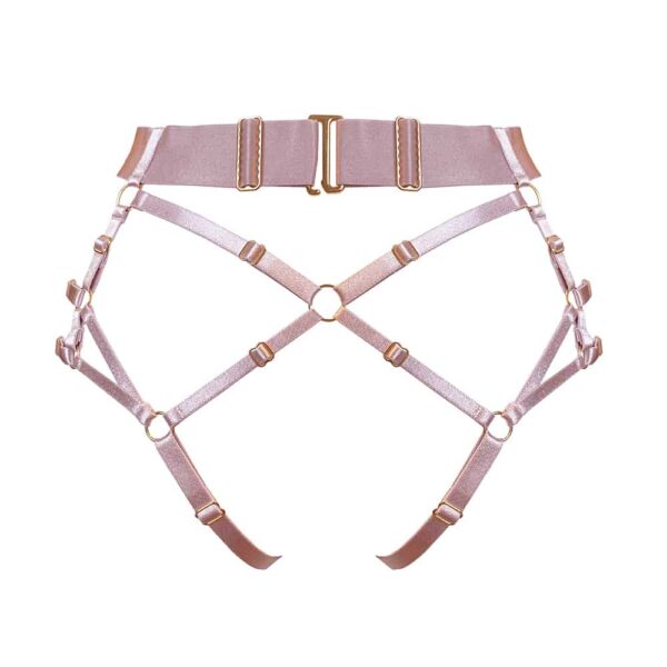 Harness panties multi styles of the collection Kora at Bordelle. This panty is pink. A wide belt made of a large elastic and decorated with a central ring as a pendant wraps around the waist. To this is added multiple thin elastic, all adjustable that form the hips and the shape of the panties. A part in satin elasticated material can be removed, it allows to obtain the result of a harness panty open or not. At the back, the elastic makes this panty completely open with an elastic placed so that it forms a thong. This elastic is also removable with a small hook embossed with the brand name.