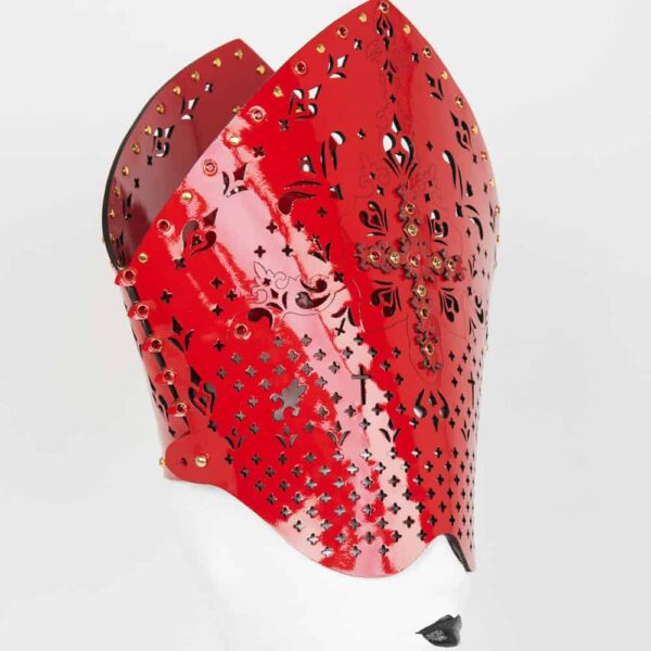 The confessional bolster is entirely handmade to order in Berlin, in the brand's workshops, from laser-cut red patent leather and red gold rivets; the Rosso confessional bolster in red leather encrusted with SWAROVSKI® is an extraordinary luxury fetish accessory.