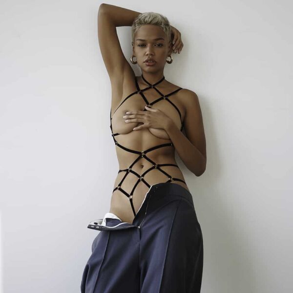 Les rubans de velours et les anneaux en métal créent un motif symétrique intéressant sur votre corps qui souligne les courbes naturelles. Le playsuit noir est fait avec des détails dorés.