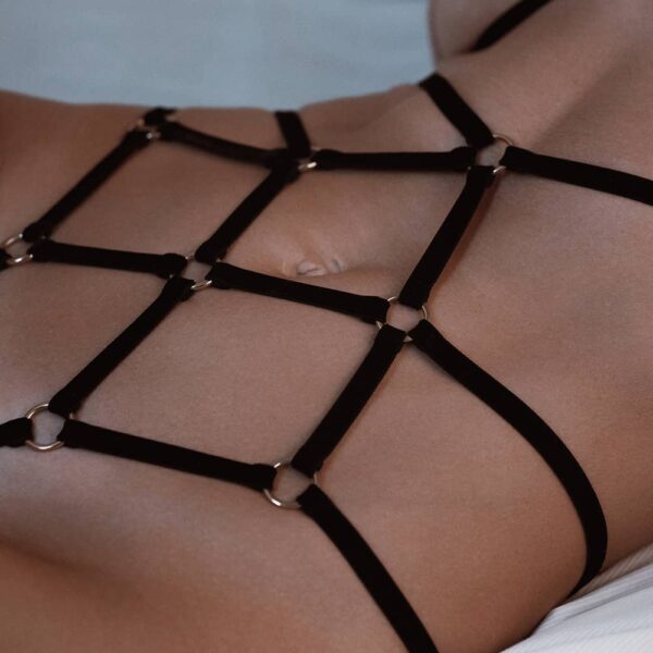 Les rubans de velours et les anneaux en métal créent un motif symétrique intéressant sur votre corps qui souligne les courbes naturelles. Le playsuit noir est fait avec des détails dorés.