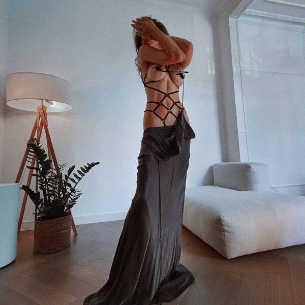 Les rubans de velours et les anneaux en métal créent un motif symétrique intéressant sur votre corps qui souligne les courbes naturelles. Le playsuit noir est fait avec des détails dorés.