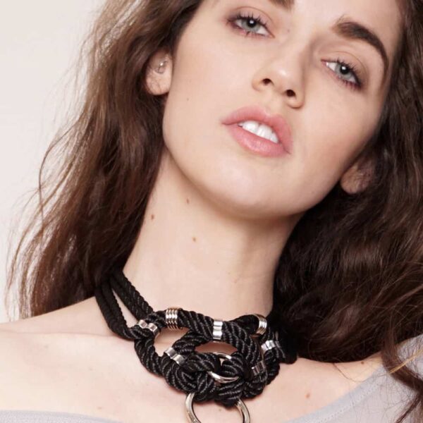 "Megami" means goddess in Japanese. This choker necklace will not leave anyone indifferent, both by its manufacture from waxed cotton rope and tied symmetrically, as well as by its design of intertwined knots with silver finishes. Closing on the neck. One size fits all & adjustable. This necklace is available at Brigade Mondaine.