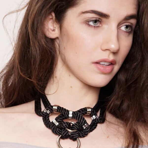 "Megami" means goddess in Japanese. This choker necklace will not leave anyone indifferent, both by its manufacture from waxed cotton rope and tied symmetrically, as well as by its design of intertwined knots with silver finishes. Closing on the neck. One size fits all & adjustable. This necklace is available at Brigade Mondaine.