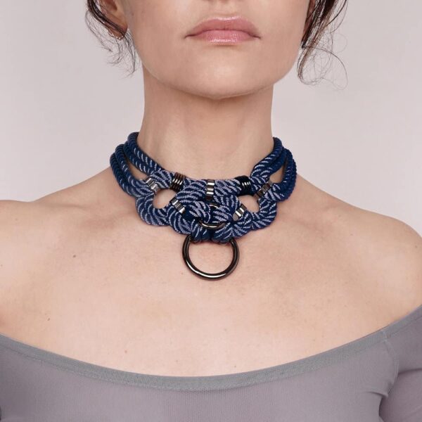 Le collier de forme choker peut être porté attaché au harnais ou seul. Fermeture au dos. Finition argentée. Totalement ajustable.