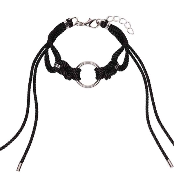 This elaborate and fitted Black Shippo Choker features a large O-ring with traditional symmetrical polyester rope knots, with long loose tails framing the neck. It is finished with silver zinc alloy and brass hardware. A clasp and chain at the back can be adjusted for a custom fit. One size fits all. Available at Brigade Mondaine.