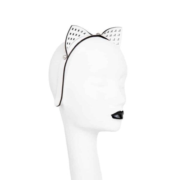 Fräulein Kink White Bianco Kitten Headband on Brigade Mondaine, entirely handcrafted to order in the brand's Berlin workshops from laser-cut patent leather and ivory bead rivets, the Bianco Kitten Headband is the ultimate versatile accessory. Pair this glamorous leather headband with your favorite outfit or, to spice things up in the bedroom, add it to your favorite lingerie look. Stylish, sexy and ultra comfortable! Custom laser-cut white patent leather kitten ears. Stitched headband in white metallic patent leather. Silver Pearl Ivory Double Cap Rivets.