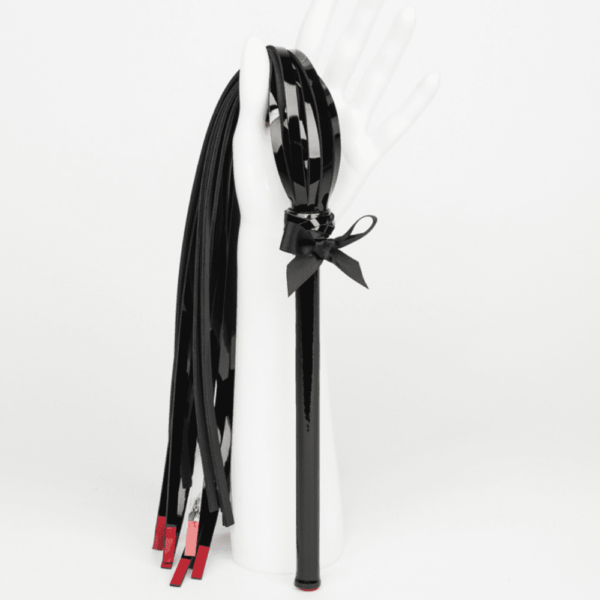 Black and red leather whip with satin bow from the French Kiss collection by Fraulein Kink, available at Brigade Mondaine