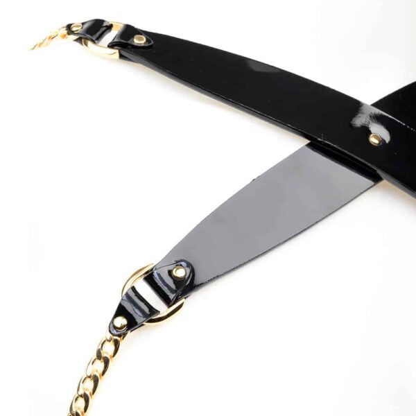 Chic and sexy! Our Rica Chain Harness is handcrafted from black patent leather, finished with high quality 24K gold plated brass rivets and chain, and adjustable satin elastic closures to comfortably wrap your body. Wear this glamorous sling over your favorite silk blouse, dress or directly against your skin. Black patent leather straps 24K gold plated brass double cap rivets and chain Adjustable black double sided satin elastic straps Adjustable stretch back hook Available in two sizes - one (S/M) and two (M/L). Please see the size chart for measurements.