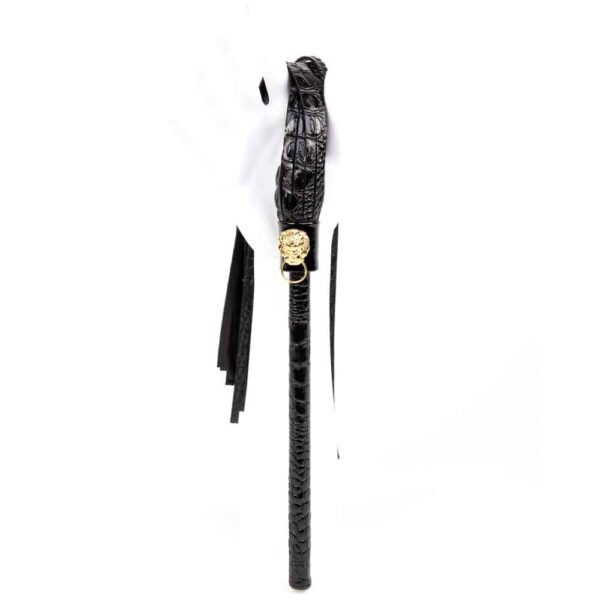The Croco Martinet from Fraulein Kink. Excite and tease with the ultimate bedroom accessory! The Crocco Flogger is handcrafted from a blend of Italian crocodile and matte black embossed leathers. The gold lion head and double brass cap rivet add the perfect finishing touch to this kinky high fashion accessory.